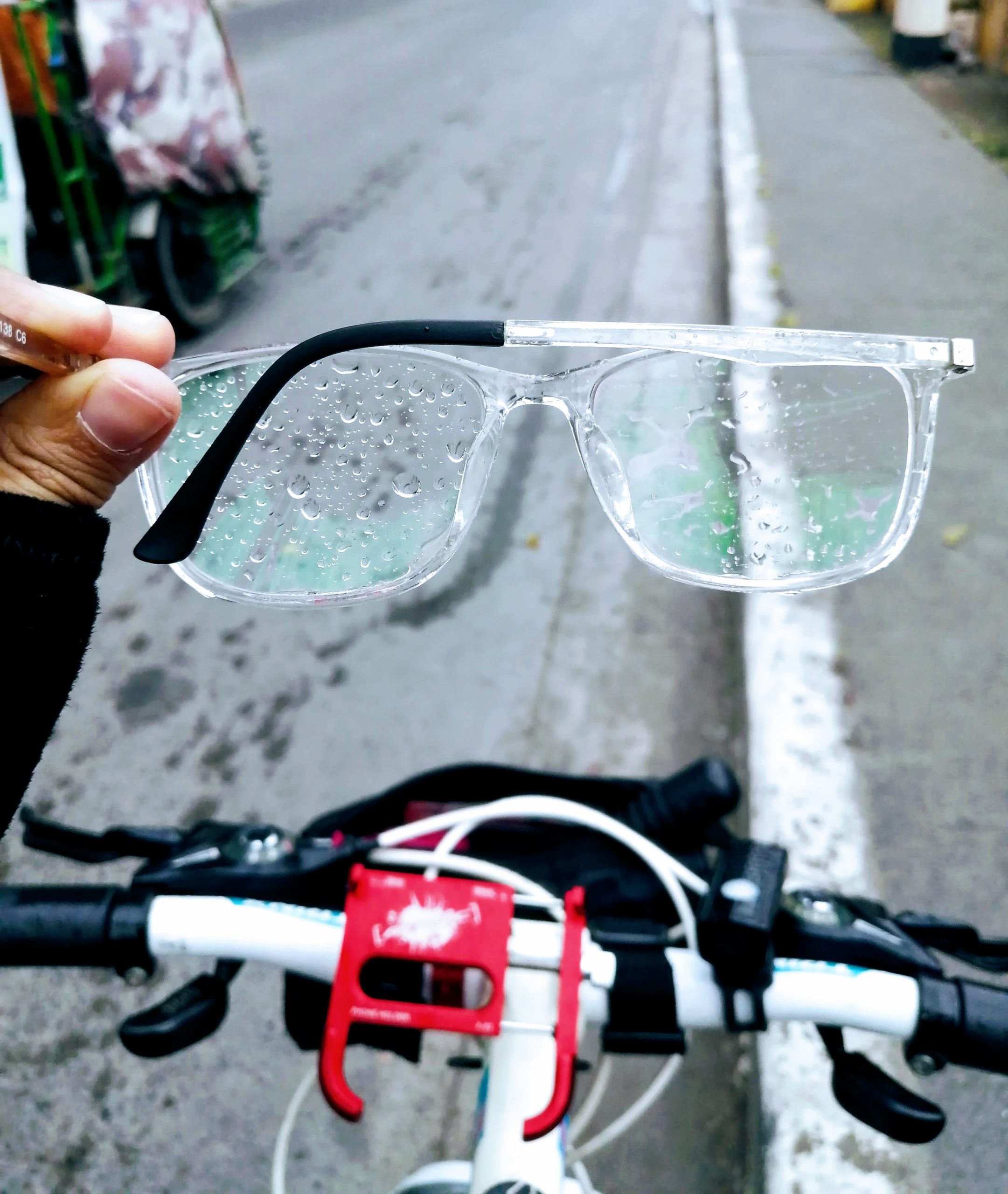 Eyeglasses drenched with rain while biking on the road
